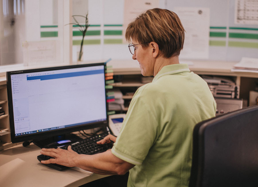 Mitarbeiterin sitz an der Rezeption